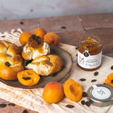 Aprikosenkonfitüre von DELIGREECE  serviert mit frischen Aprikosen und Brötchen